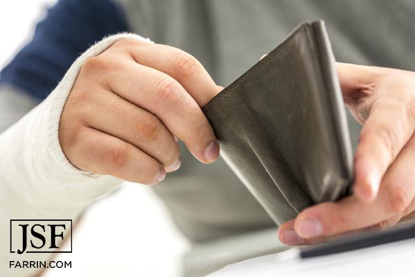 A person looks through brown wallet.