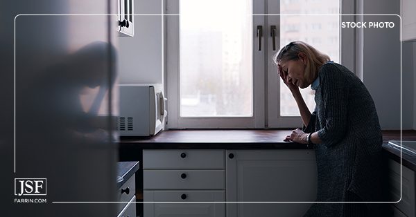 A woman is ill in her kitchen, affected by an FDA Failure.